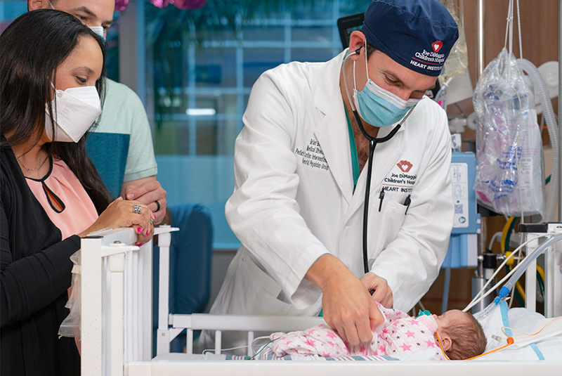 Brian Boe, MD, Medical Director, Pediatric Cardiac Interventional Services, and Amelia, who was born with patent ductus arterosis (PDA), with her parents.