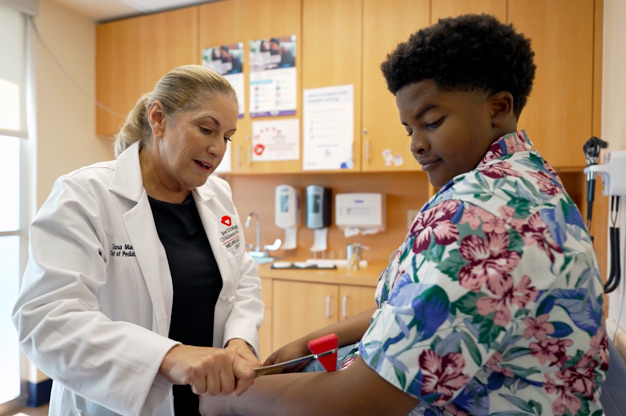 Diana Martinez with a young neurology patient performing and examination